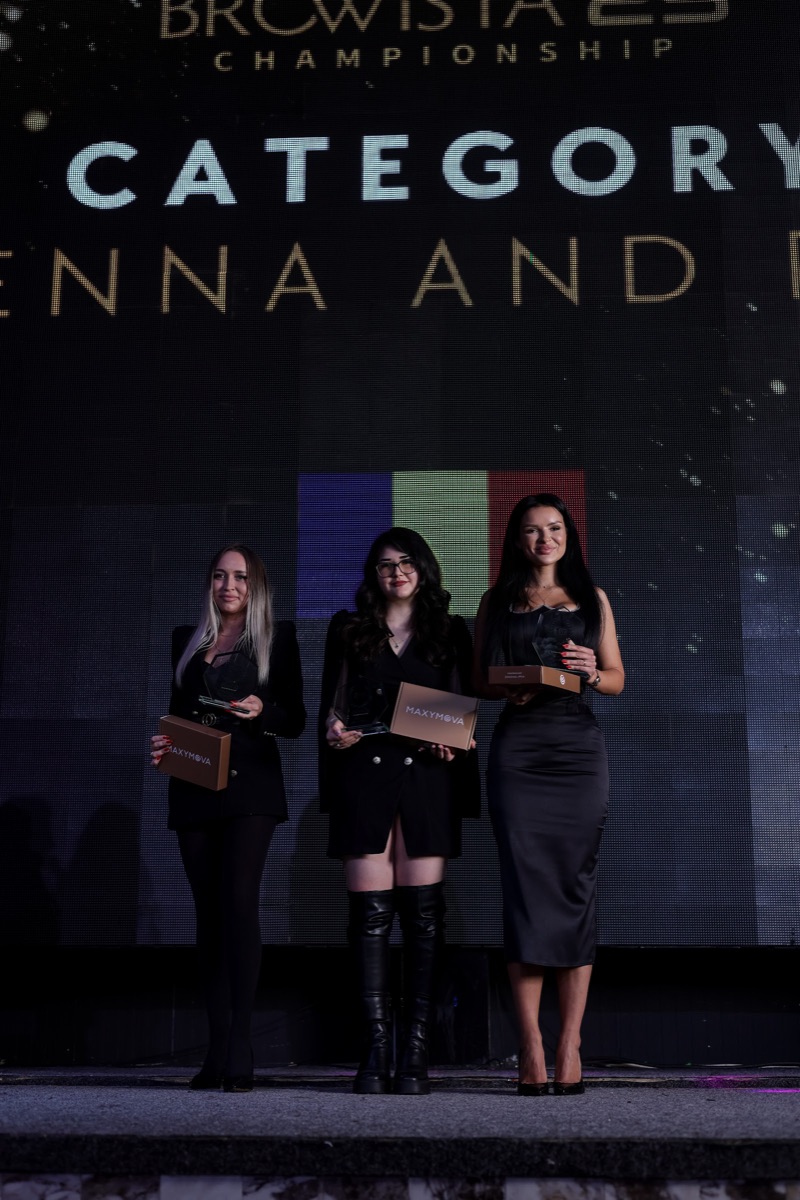 Trei câștigătoare pe scenă, cu premiile în mână, în fața ecranului cu tricolorul și categoria Henna and Dye